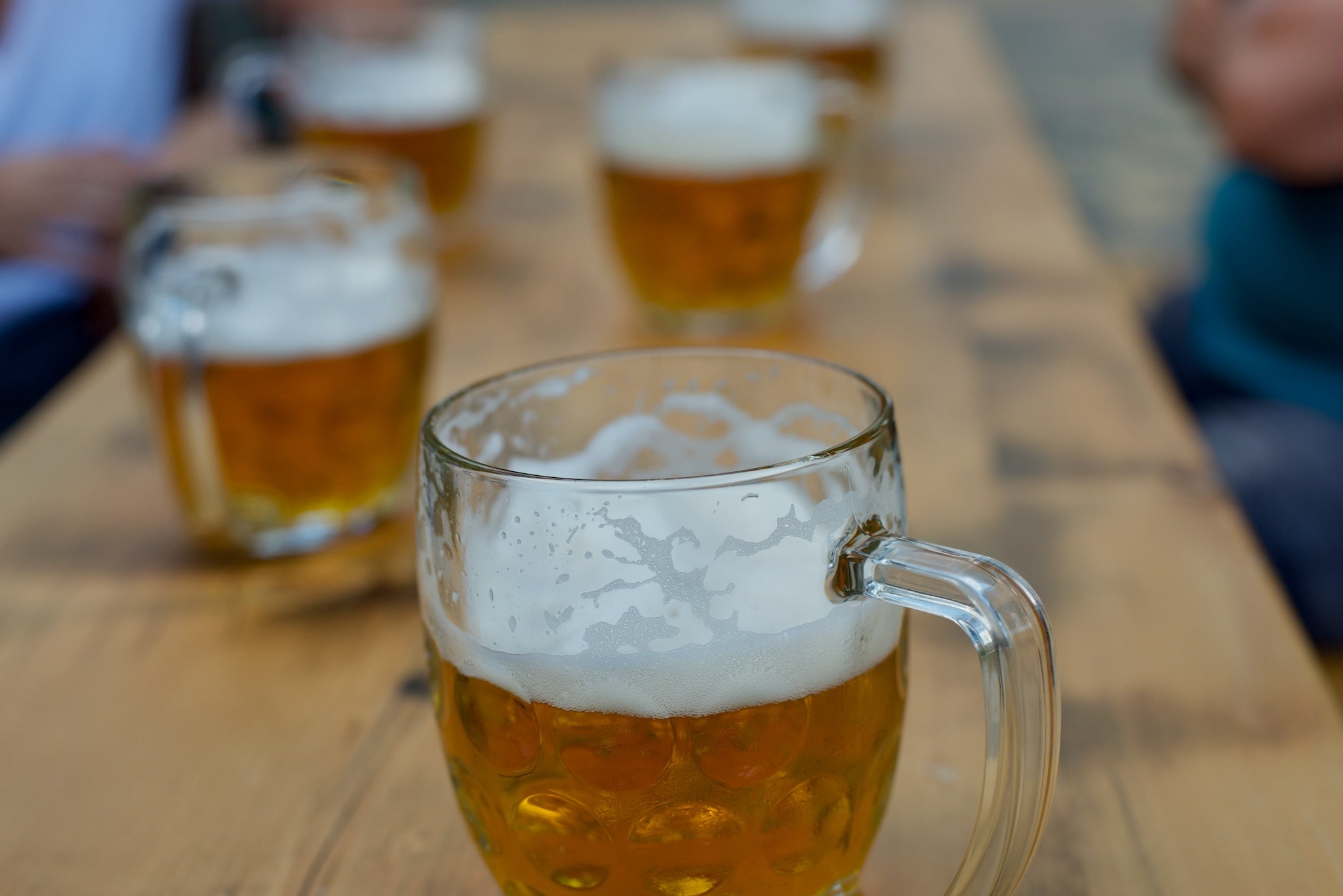 Tankards of deer on a long wooden table in a german Biergärten